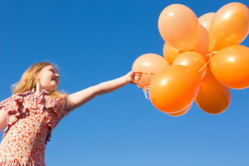 happy girl with orange balloons outdoor
