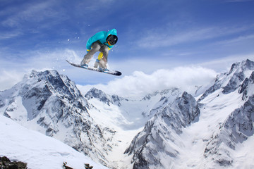 Flying snowboarder on mountains. Extreme sport.