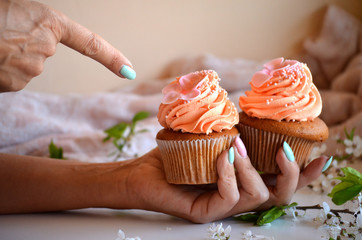 The girl shows a finger on cupcakes