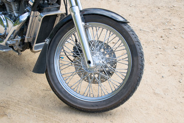 Close up front wheel motorcycle chopper  on the floor.