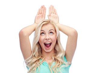 happy smiling young woman making bunny ears