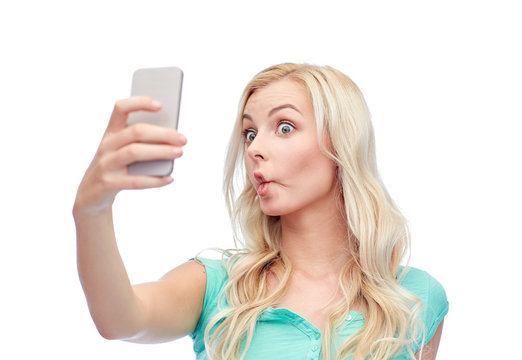 funny young woman taking selfie with smartphone