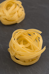 Raw yellow tagliatelle pasta on a slate plate