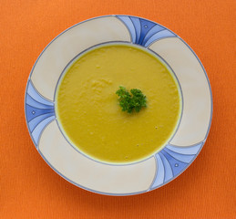 plate of pumpkin soup on  orange background