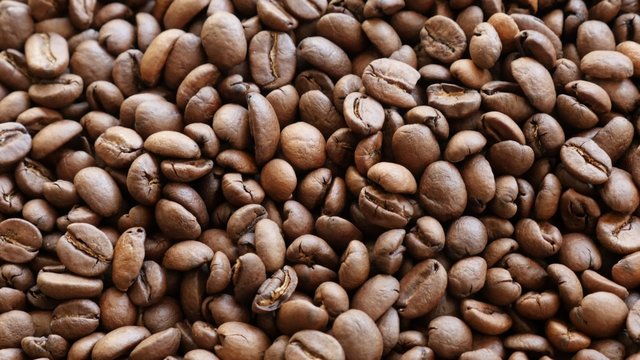Lot of Arabic type roasted coffee beans on table slow tilt 4K 2160p 30fps UHD video - High quality coffee beans of Arabica type 4K 3840X2160 UltraHD footage