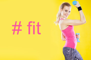 Happy fitness woman with dumbbells on isolated yellow background