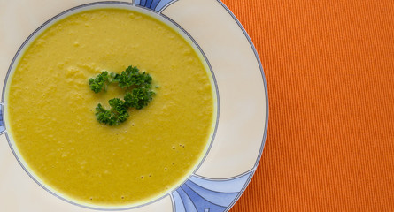  plate of pumpkin soup on  orange background