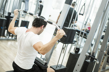 Naklejka na ściany i meble Young man training in the gym