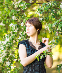 Spring  girl outdoor portrait in blooming trees. Beauty Romantic woman in flowers. Sensual Lady. Beautiful Woman Enjoying Nature. 
