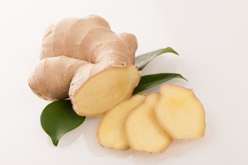 Ginger root with green leaves isolated over white.