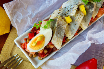 Salted herring with salad on the table.
