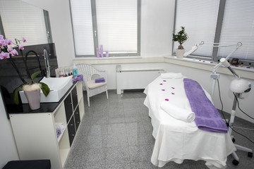 Massage table and equipment in modern beauty salon.