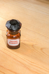 bottle of procaine hydrochloride on wooden background, pharmacy - obrazy, fototapety, plakaty