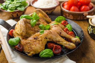 Chicken baked with tomatoes and basil on iron pan