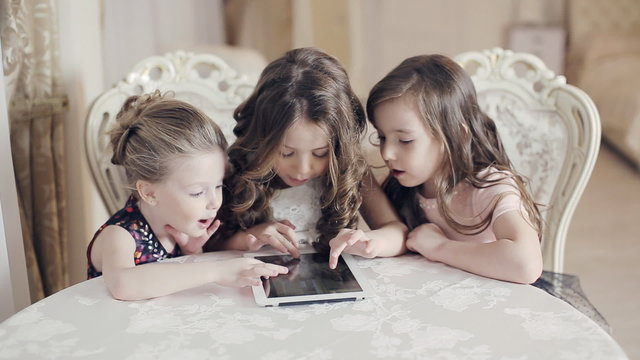 Girls watching photos in the tablet and wonder