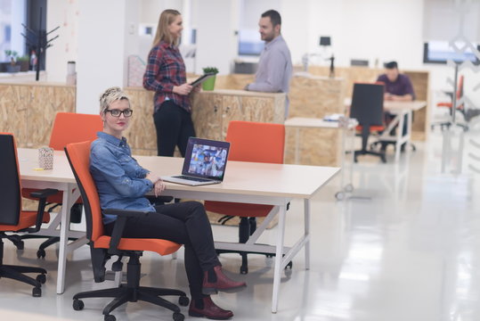 portrait of young business woman at office with team in backgrou