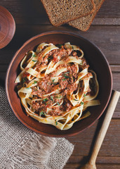 pasta tagliatelle with bolgnese sauce on the wooden table, rustic style