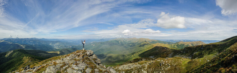young girl practices yoga on a mountain top in the mountains