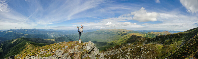 Young woman practices yoga on a mountain top, Carpathian mountains