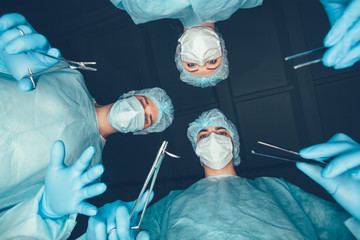 Medical team  hospital performing operation. Group of surgeon at work in operating theatre room....