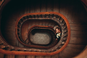 happy luxury wedding couple is standing and kissing on the stairs