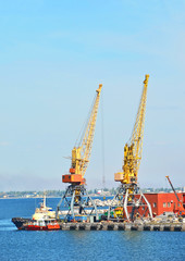 Tugboat and freight train under port crane