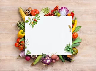 Muurstickers Healthy food background and Copy space / studio photography of white paper surrounded by fresh vegetables on old wooden table © Romario Ien
