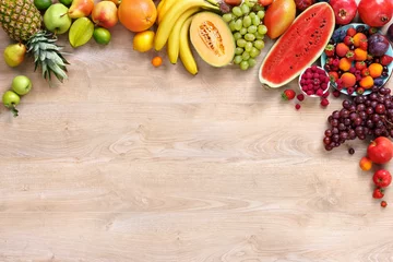 Poster Healthy fruits background / studio photo of different fruits on wooden table © Romario Ien