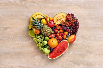 Heart symbol. Fruits diet concept. Healthy eating concept / food photography of heart made from different fruits on wooden table