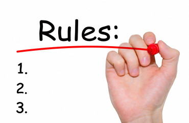 Hand writing "Rules" with red marker on transparent wipe board.