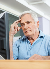 Worried Senior Student Looking At Computer In Class