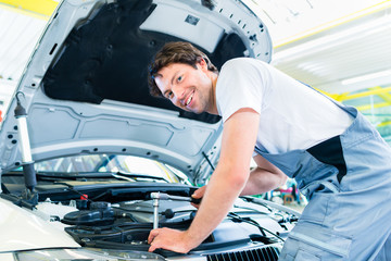 car mechanic working with tool in service workshop