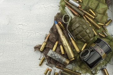 Different types of ammunition on a camouflage background. Preparing for war. Possession of...