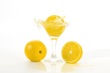 lemon slice falls in a glass with a cocktail
