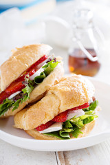 Croissant sandwich with brie, salad and strawberry