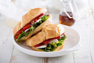 Croissant sandwich with brie, salad and strawberry