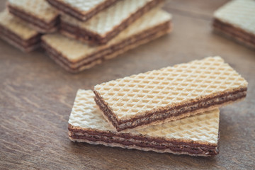 Wafers with chocolate on wooden table
