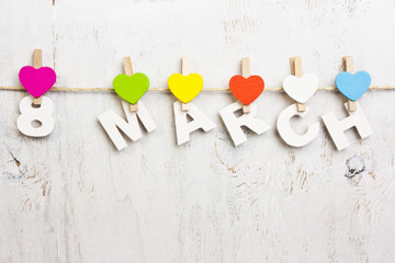 8 March and multicolored hearts on a white background old wooden