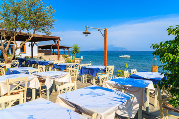 Typical Greek tavern in small fishing village on coast of Samos island, Greece