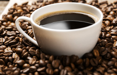 cup of hot coffee on coffee beans background