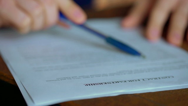 Businessman sitting at the table and checking contract
