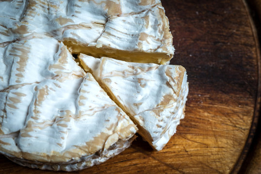 SLice of camembert cheese rustic table