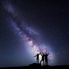Fototapeta na wymiar Milky Way. Night sky with silhouette of a happy family