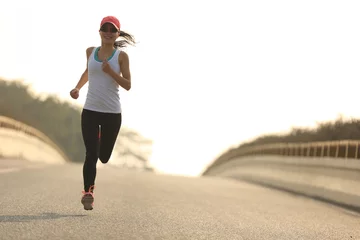 Afwasbaar Fotobehang Joggen jonge fitnessvrouw trailrunner die op de stadsweg loopt