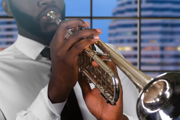 Trumpet player on city background.