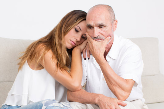 älterer Mann mit junger Frau traurig 