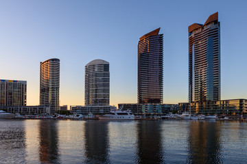 Residential high rise buildings and Yarra waterfront with docked Yachts in Docklands, Melbourne, early morning.