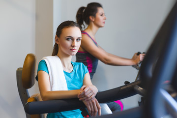 Woman girl resting at the gym on a cross trainer
