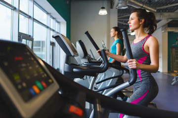 Woman exercising at the gym on a cross trainer