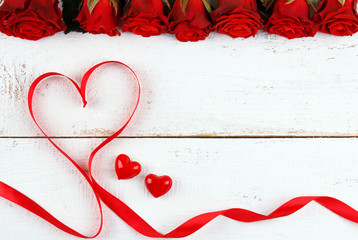 Heart made of red ribbon with red roses and pretty little hearts on white background. Valentines...
